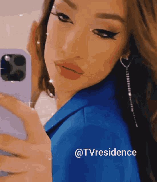 a woman in a blue jacket takes a selfie with the hashtag @tvresidence on the bottom