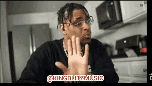 a man wearing glasses and a black shirt says " @kingblitzmusic " on the bottom