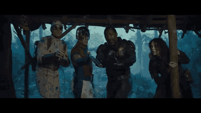 a group of people are standing next to each other in a dark room