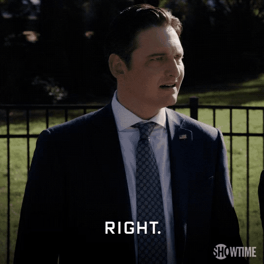 a man in a suit and tie is standing in front of a fence and says right