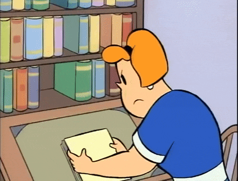 a cartoon character sits at a desk reading a book