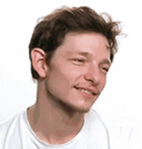 a close up of a man 's face with a white shirt on .