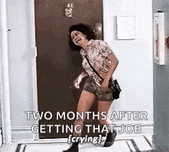 a woman is standing in front of a door and laughing while getting that job .