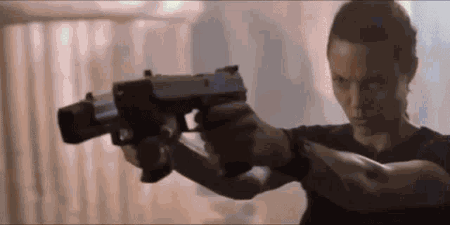a woman is holding two guns in her hands and pointing them at each other .