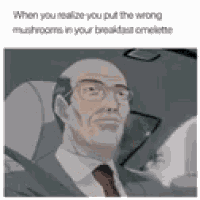 a man in a suit and tie is driving a car and making a funny face .