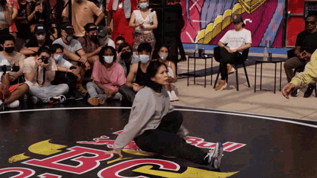 a group of people are watching a woman perform on a stage that has the letters bc on it