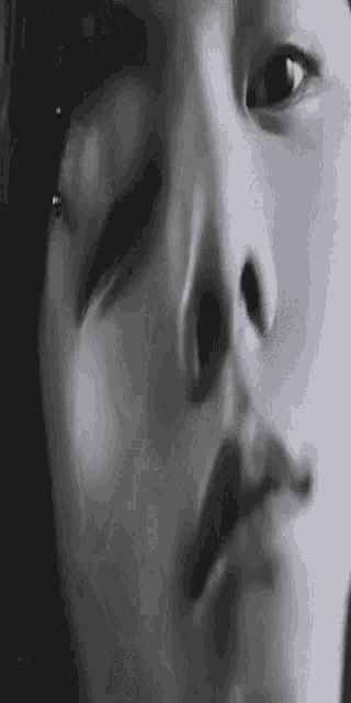 a close up of a person 's face with their eyes closed and a nose piercing .