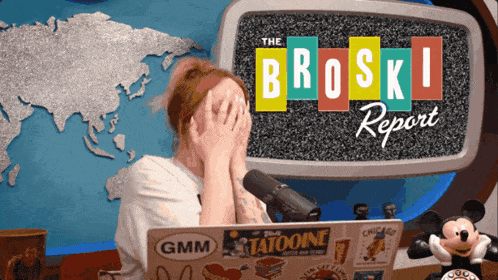 a woman covering her face in front of a screen that says broski report