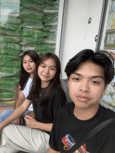 a boy and two girls sit in front of a sign that says hdb