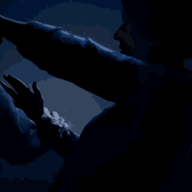 a person 's hand is visible against a dark background