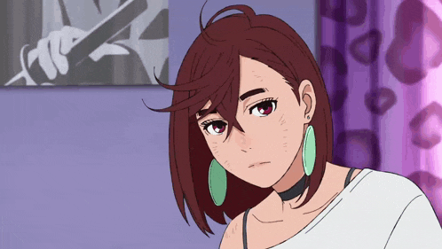 a girl with brown hair and green earrings is standing in front of a purple wall
