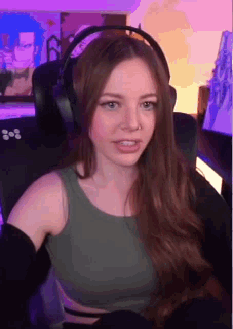 a woman wearing headphones is sitting in front of a computer .