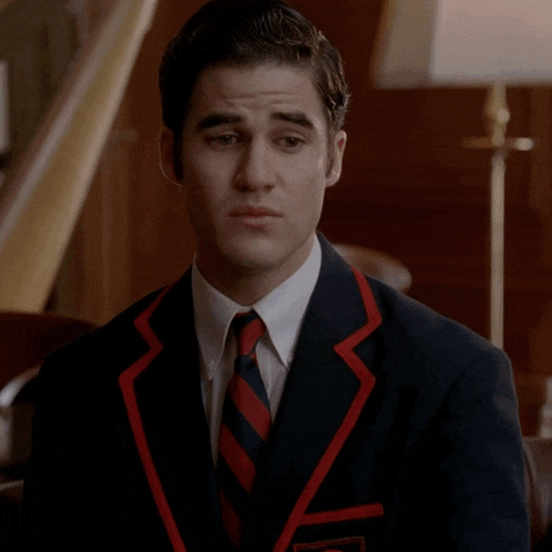 a man wearing a suit and tie with a name tag that says ' abercrombie & fitch ' on it