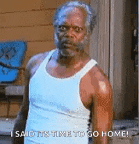 a man in a white tank top is standing in front of a door and saying `` i said its time to go home ! ''