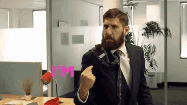 a man in a suit and tie is making a fist in the air with the word i 'm behind him