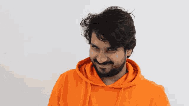 a man with a beard wearing a bright orange hoodie