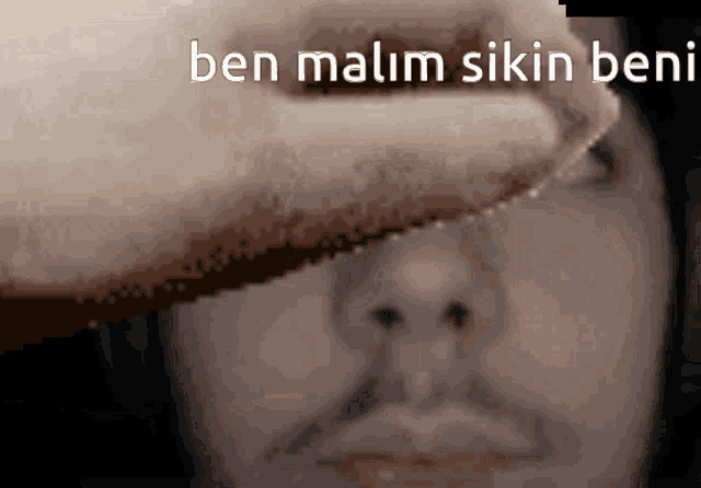 a close up of a man 's face with the words ben malim akin beni written above him