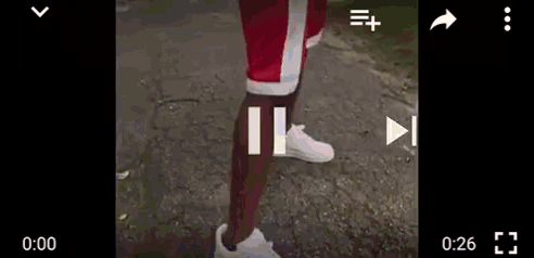 a person wearing red shorts and white shoes is walking on a sidewalk .