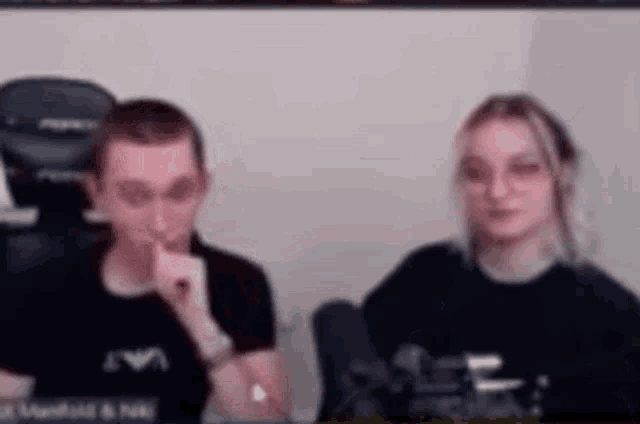 a man and a woman are sitting next to each other in front of a computer screen .