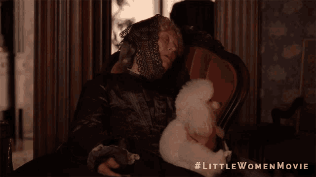 a woman holding a stuffed animal with the little women movie written on the bottom right
