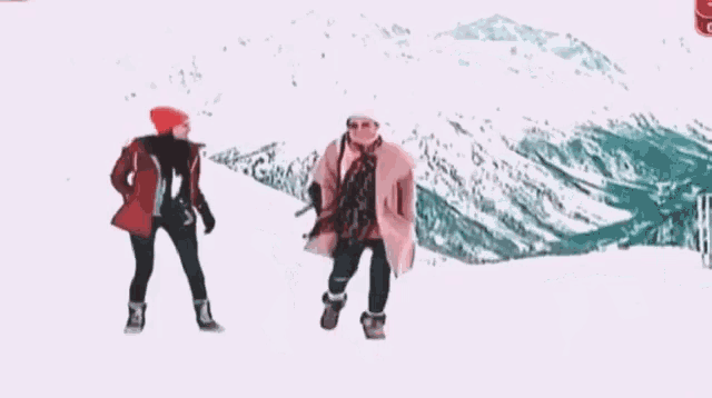 two women are jumping in the air in the snow