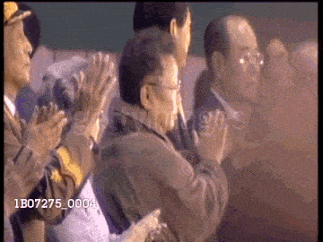a group of people applauding with the number 1b07275_0004 visible in the corner