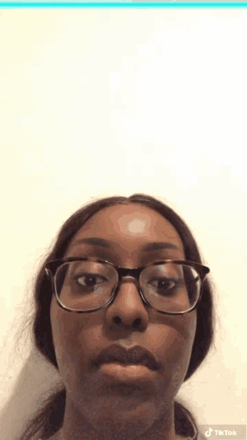 a woman wearing glasses has tiktok written on the bottom