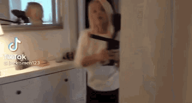 a person is standing in a room holding a knife in their hand .