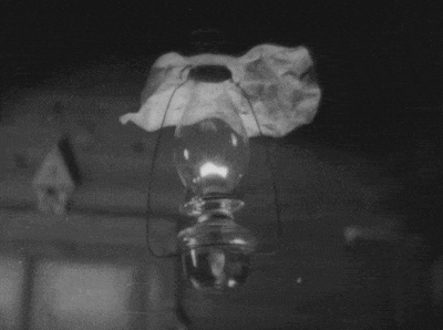a black and white photo of a lantern with a piece of paper on top of it