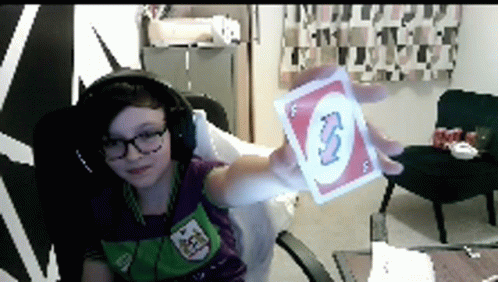 a person wearing headphones is holding a uno card