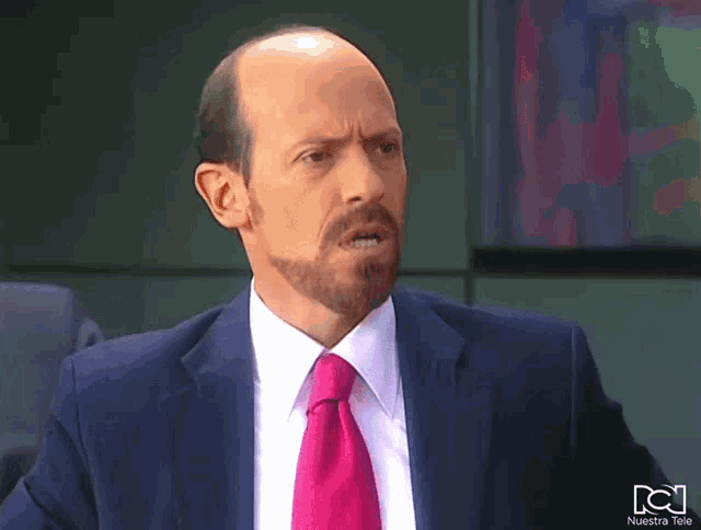 a man in a suit and tie with nuestra tele on the bottom right