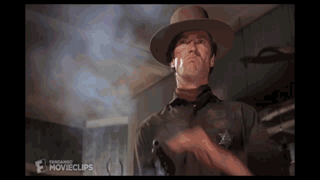 a man in a sheriff 's uniform is holding a gun in front of a screen that says fangando movieclips
