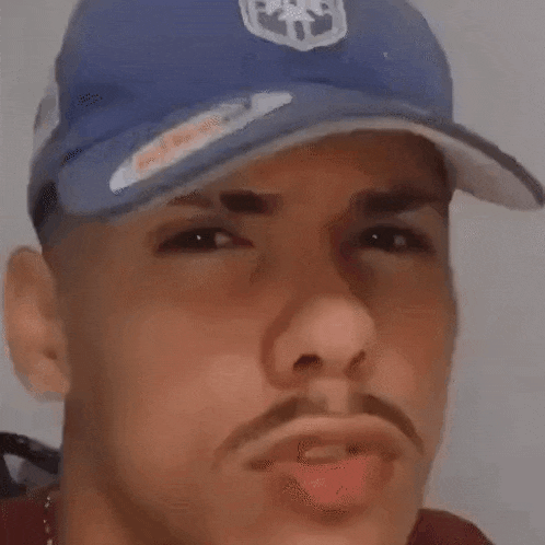 a close up of a man wearing a blue hat .