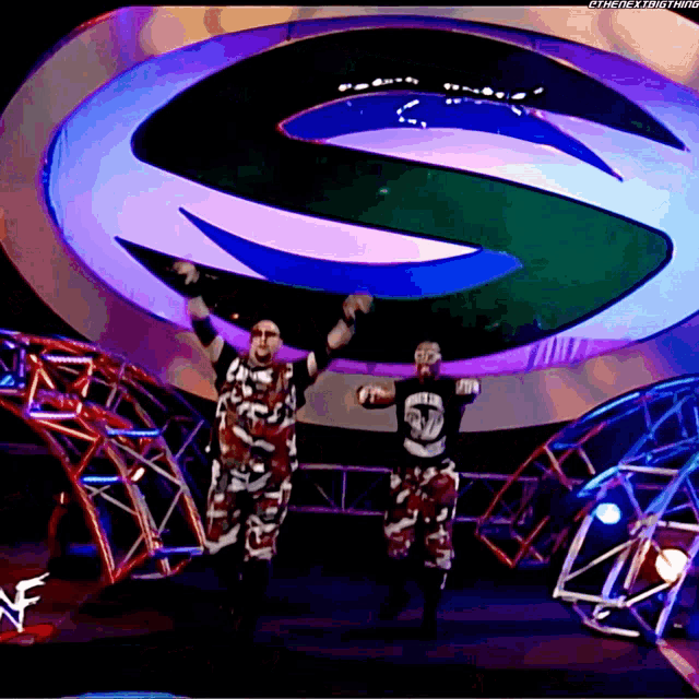 two wrestlers are standing in front of a large s