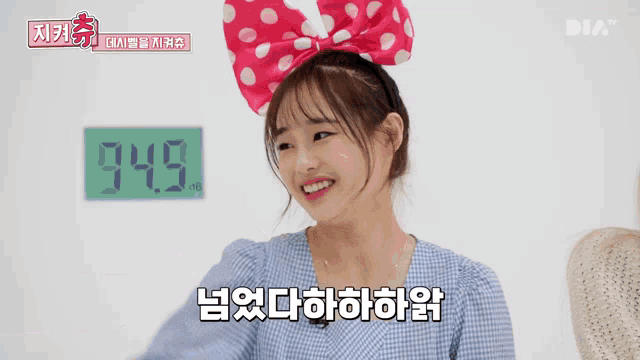a girl with a pink bow on her head stands in front of a scale that reads 74.5 kg