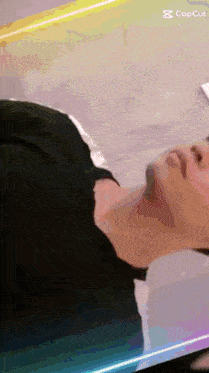 a man with a beard is laying on a bed with his head down and his mouth open .