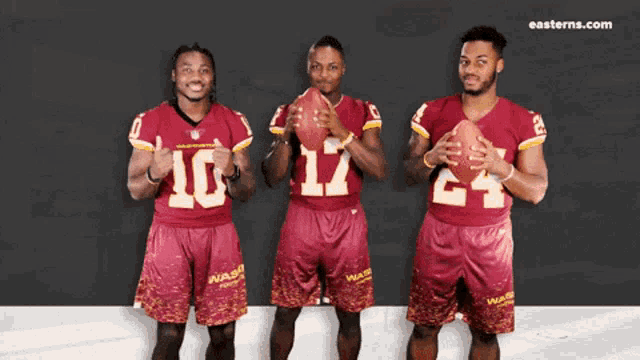 three washington redskins players holding footballs in front of easterns.com