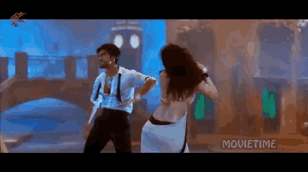 a man and a woman are dancing in front of a sign that says movie time