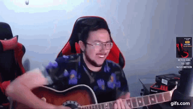 a man is playing a guitar in front of a gifs.com logo