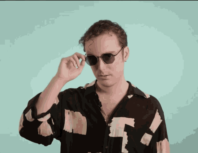 a man wearing sunglasses and a shirt with a t on it