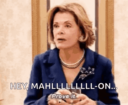 a woman in a blue suit and pearl necklace is saying `` hey , mahllllll-on ... prove it . ''