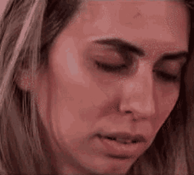 a close up of a woman 's face with a slight smirk on her face .