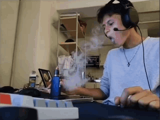 a man wearing headphones and smoking an electronic cigarette