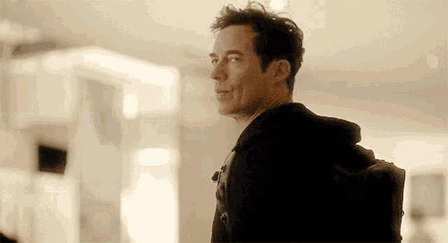 a man in a black hoodie with a backpack on his back