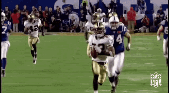 a group of football players are running on a field with a nfl logo in the background .