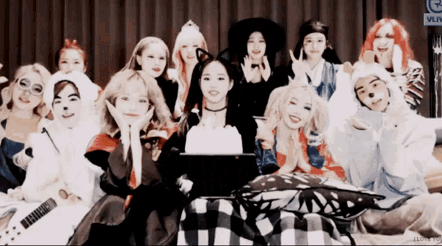 a group of people are posing for a picture with a vlive logo in the corner