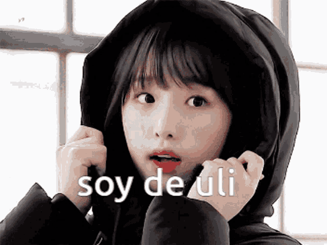a girl wearing a hooded jacket with the words soy de uli written on it