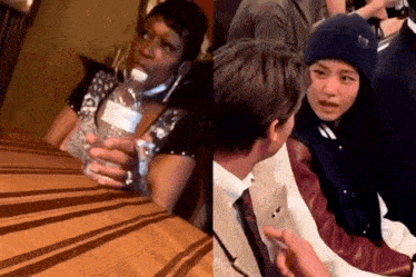 a woman is sitting at a table holding a bottle of water next to a boy .