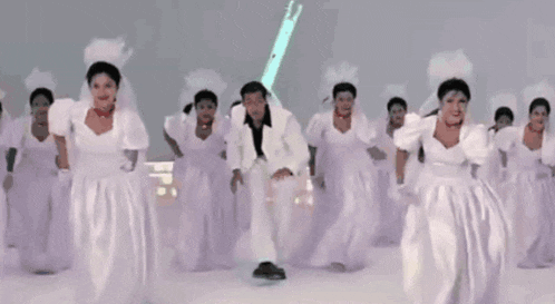 a man in a white suit is surrounded by bridesmaids in white dresses