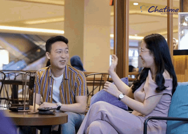 a man and a woman sit at a table in a chatime restaurant